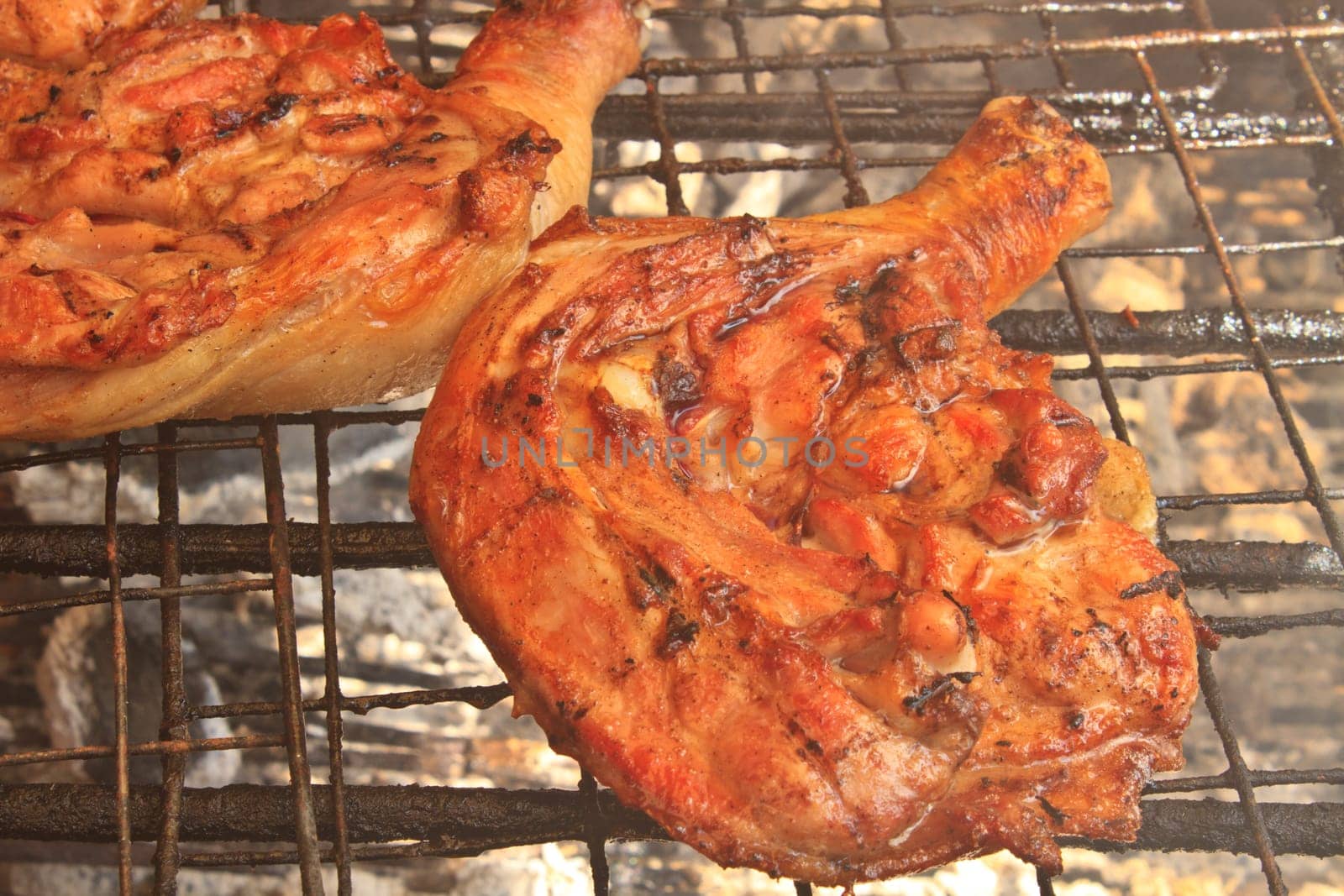 Grilled chicken thigh on the flaming grill