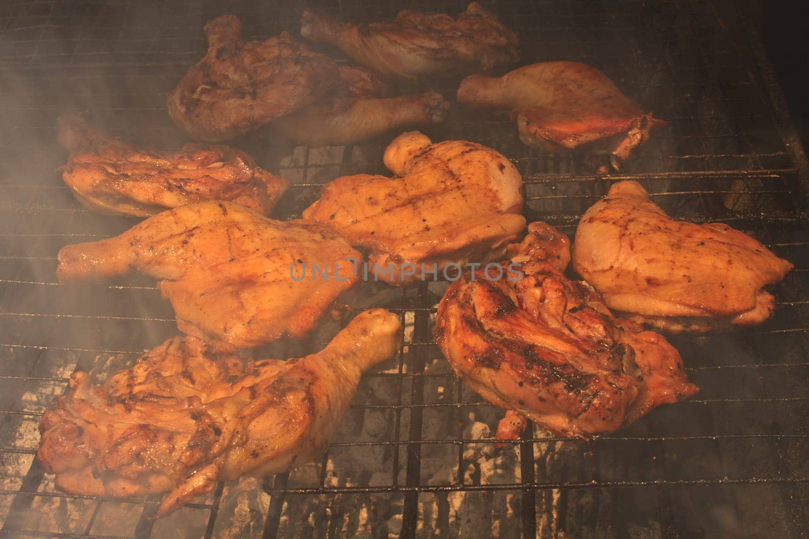 Grilled chicken thigh on the flaming grill
