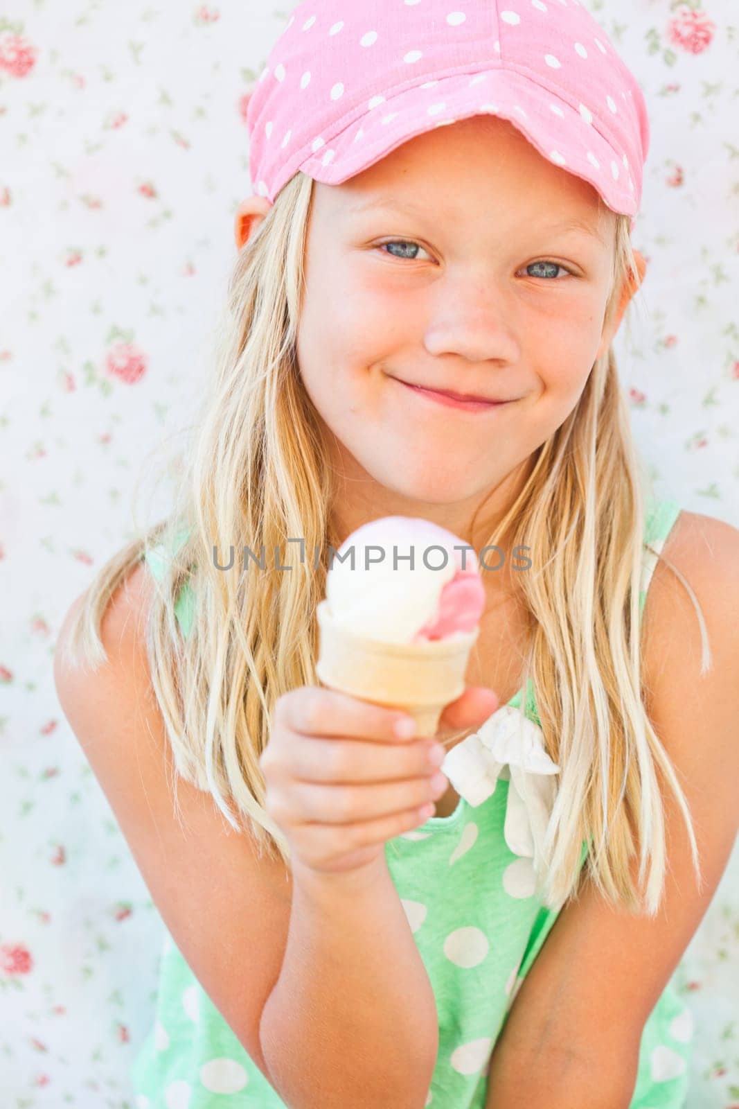 Cute smiling young girl holding ice cream cone
