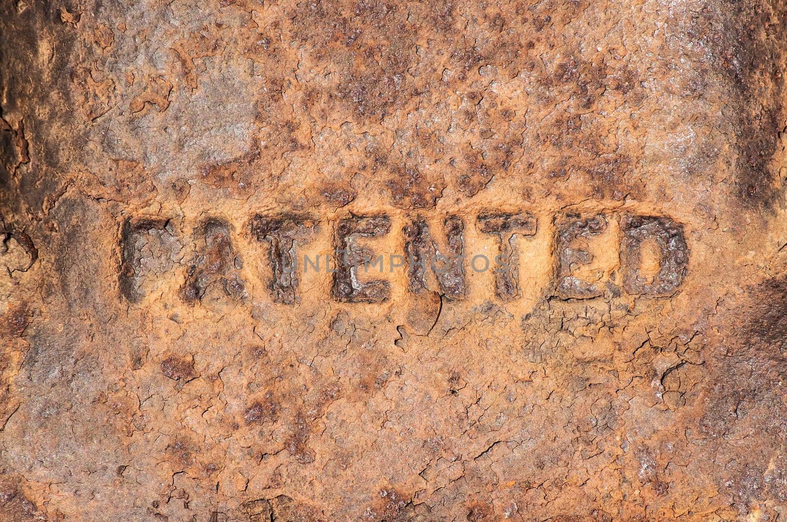 Old weathered rusty cast iron surface labeled "patented"""