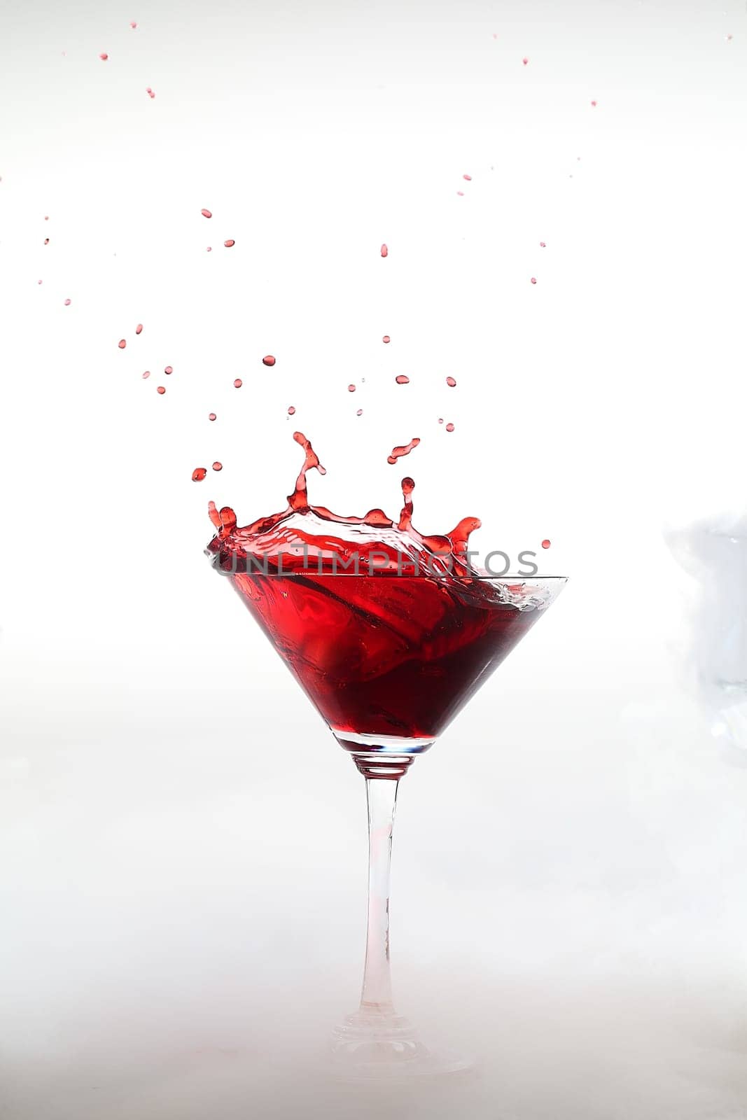 Vertical photo of a splash colored drink with smoke