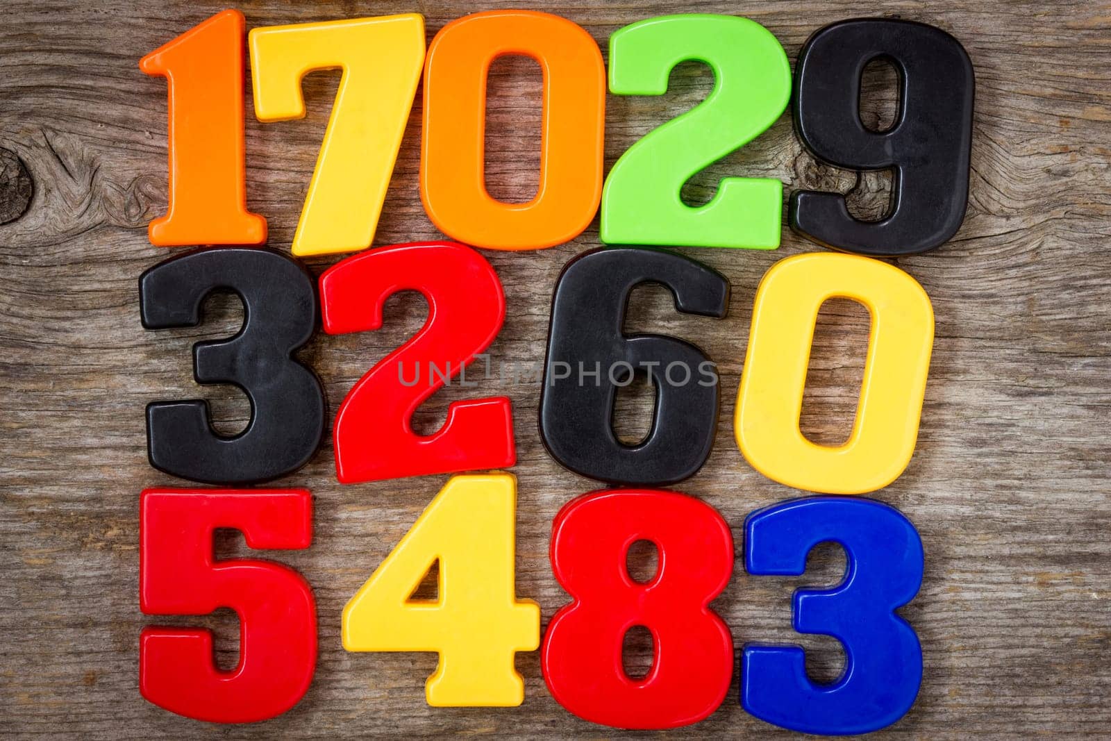 Colorful plastic numbers on the wooden background