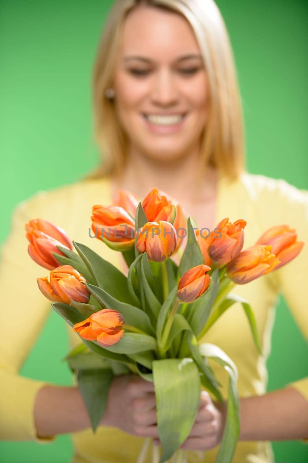Bouquet of orange spring tulip flowers smiling woman in background