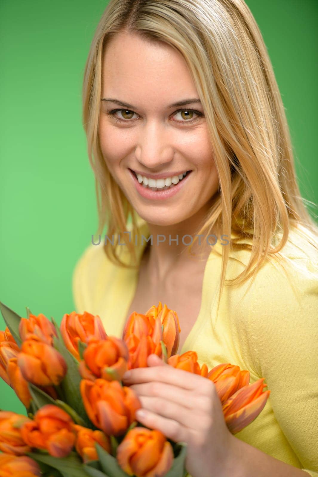 Smiling woman hold spring flowers bouquet of orange tulips