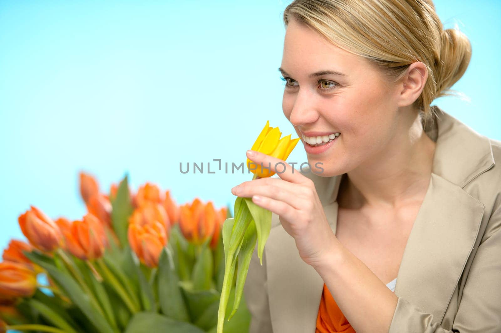 Woman smelling one yellow tulip spring flowers smiling