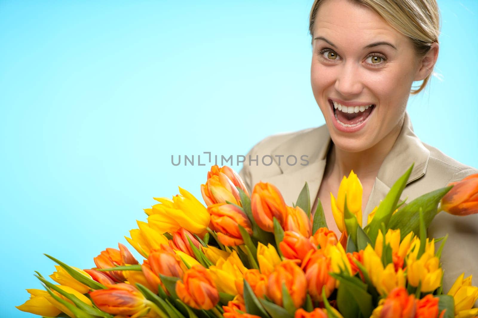 Cheerful woman with bunch of orange yellow spring tulips