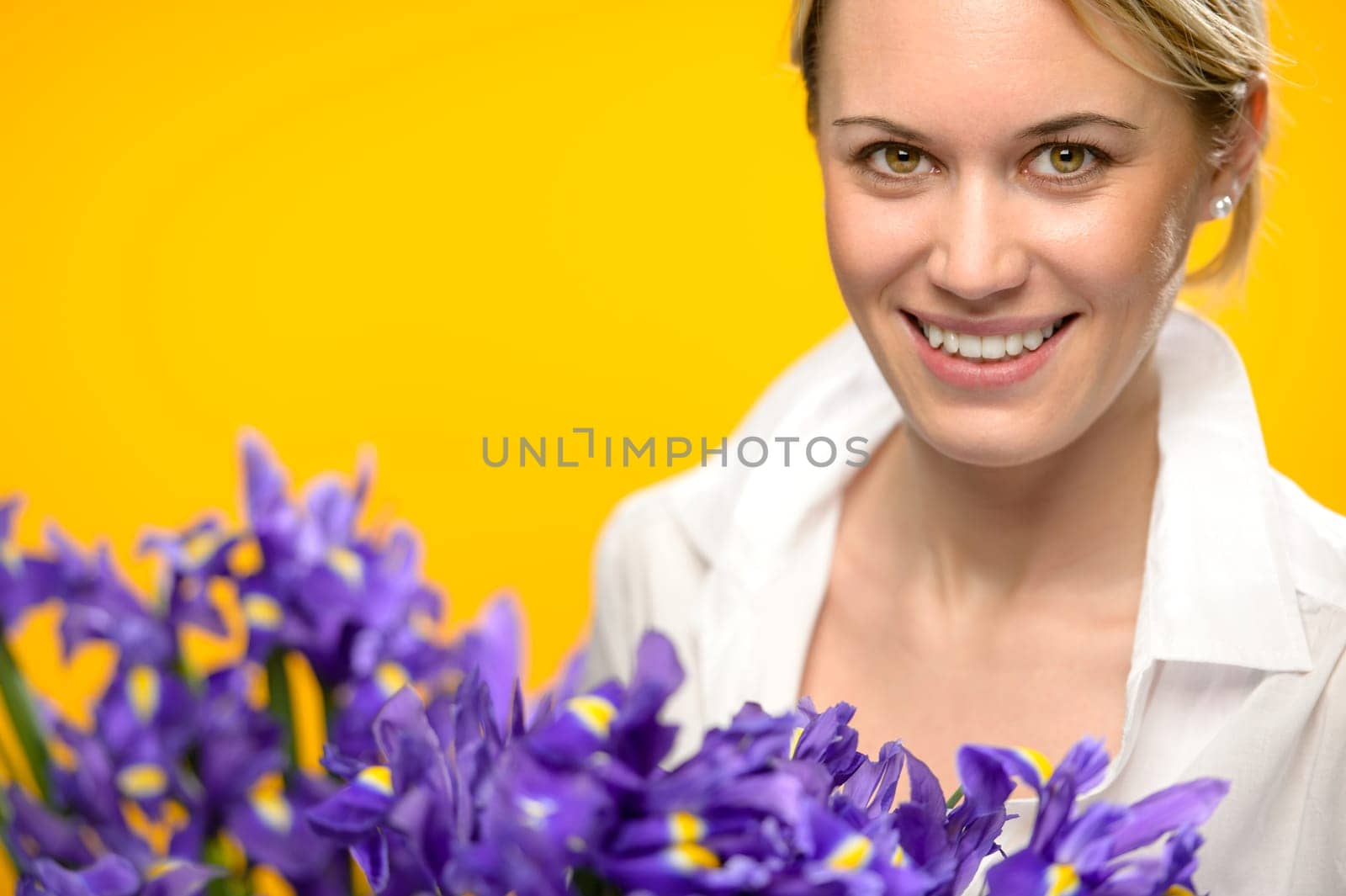 Smiling woman with spring blue flowers iris