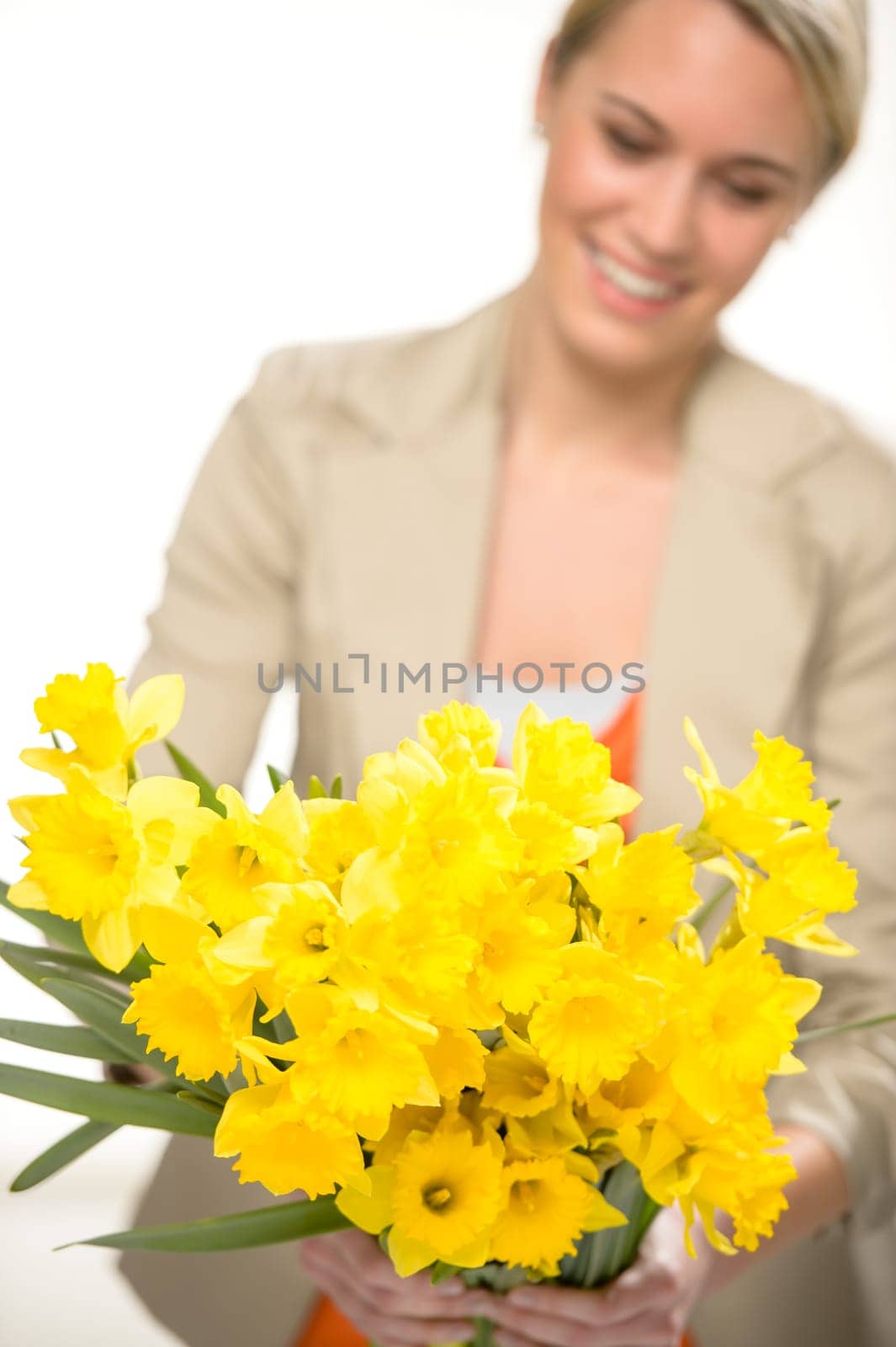 Bunch of yellow spring narcissus flowers smiling woman in background