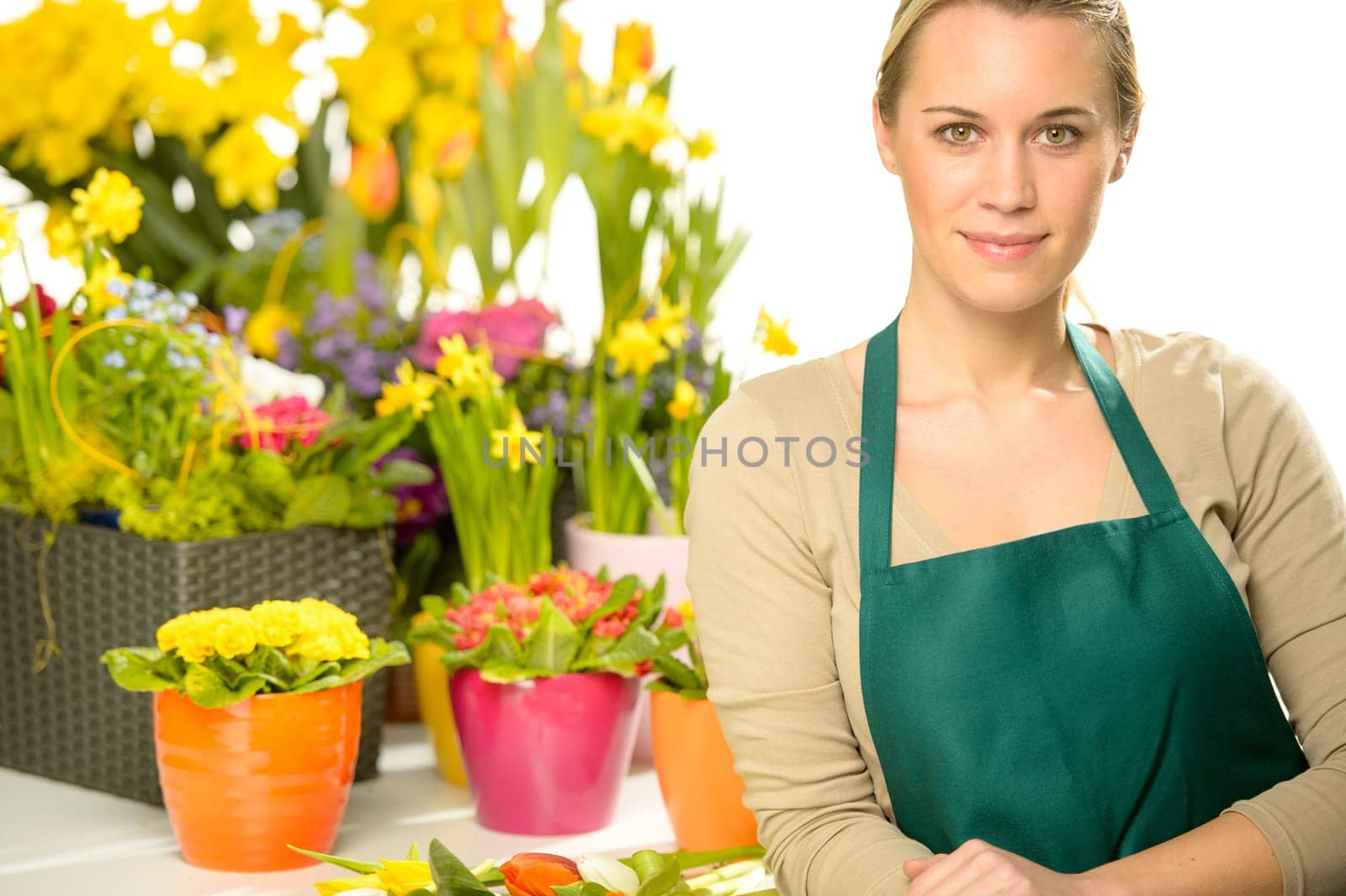 Florist with spring potted flowers colorful looking at camera