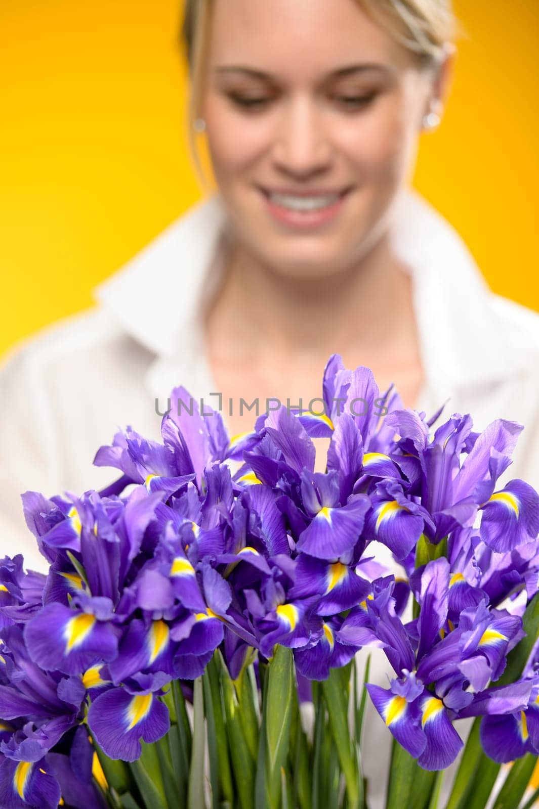 Bouquet of blue spring iris flowers smiling woman in background