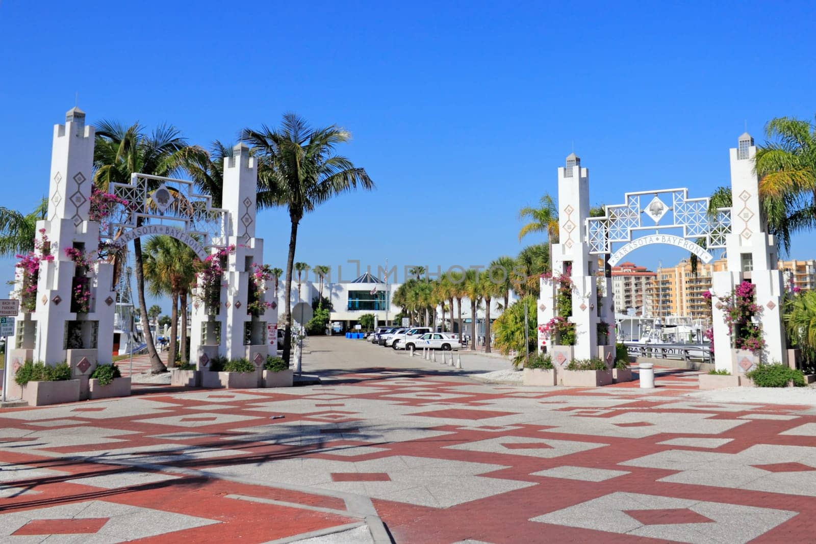 SARASOTA, FLORIDA - MAY 9, 2013: A couple of very beautiful entrances to Sarasota Bay front that are mostly white, ornate, growing purple bougainvillea flowers and other foliage and palm trees.