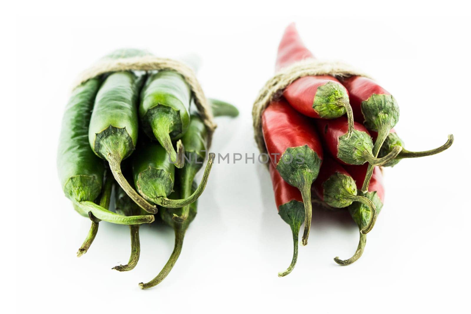 Two sets of red and green hot chili pepper on a white background