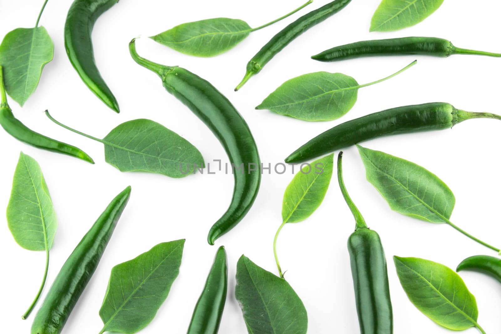 green hot chili pepper with leaves on a white background