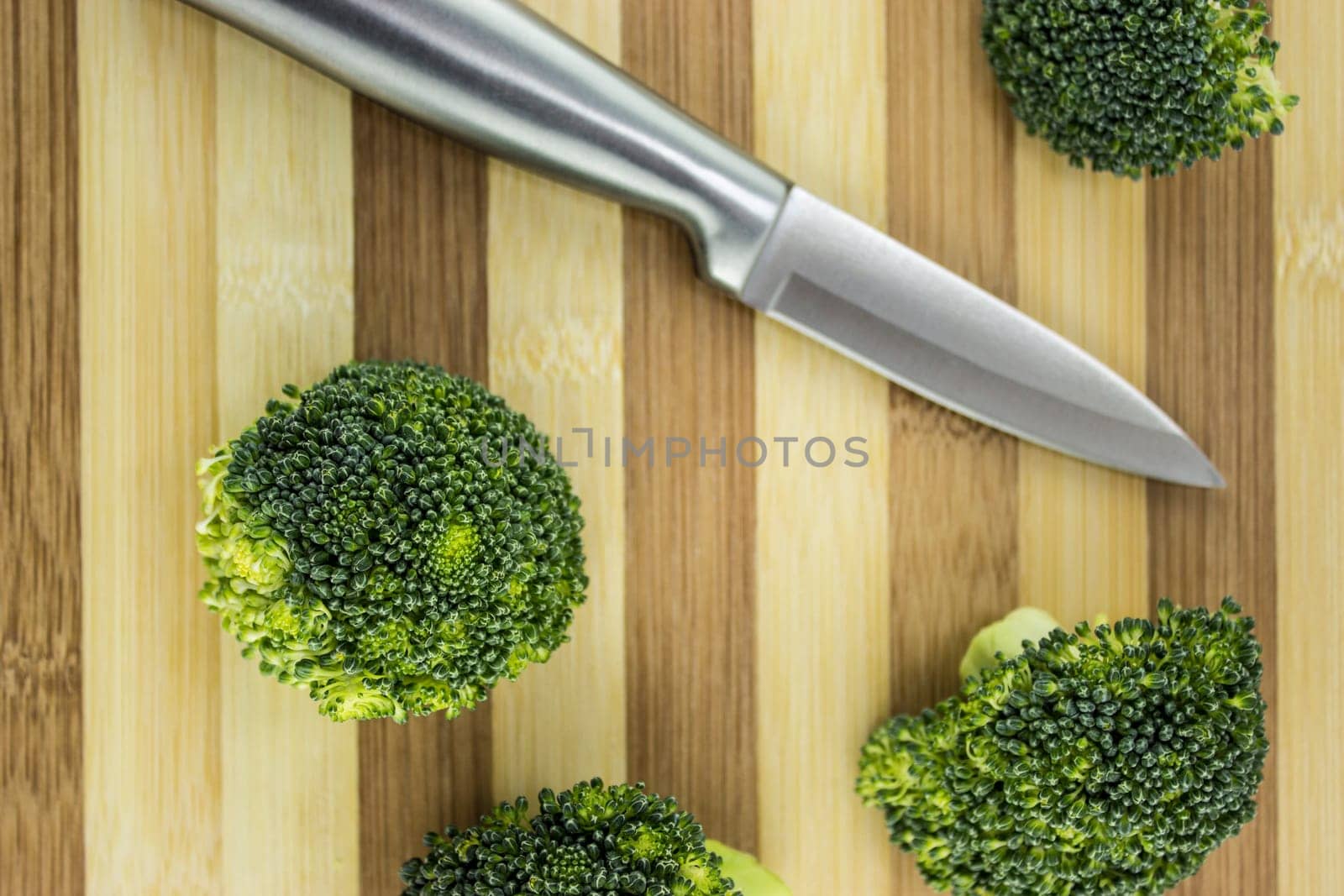 Fresh broccoli on wood with knife.