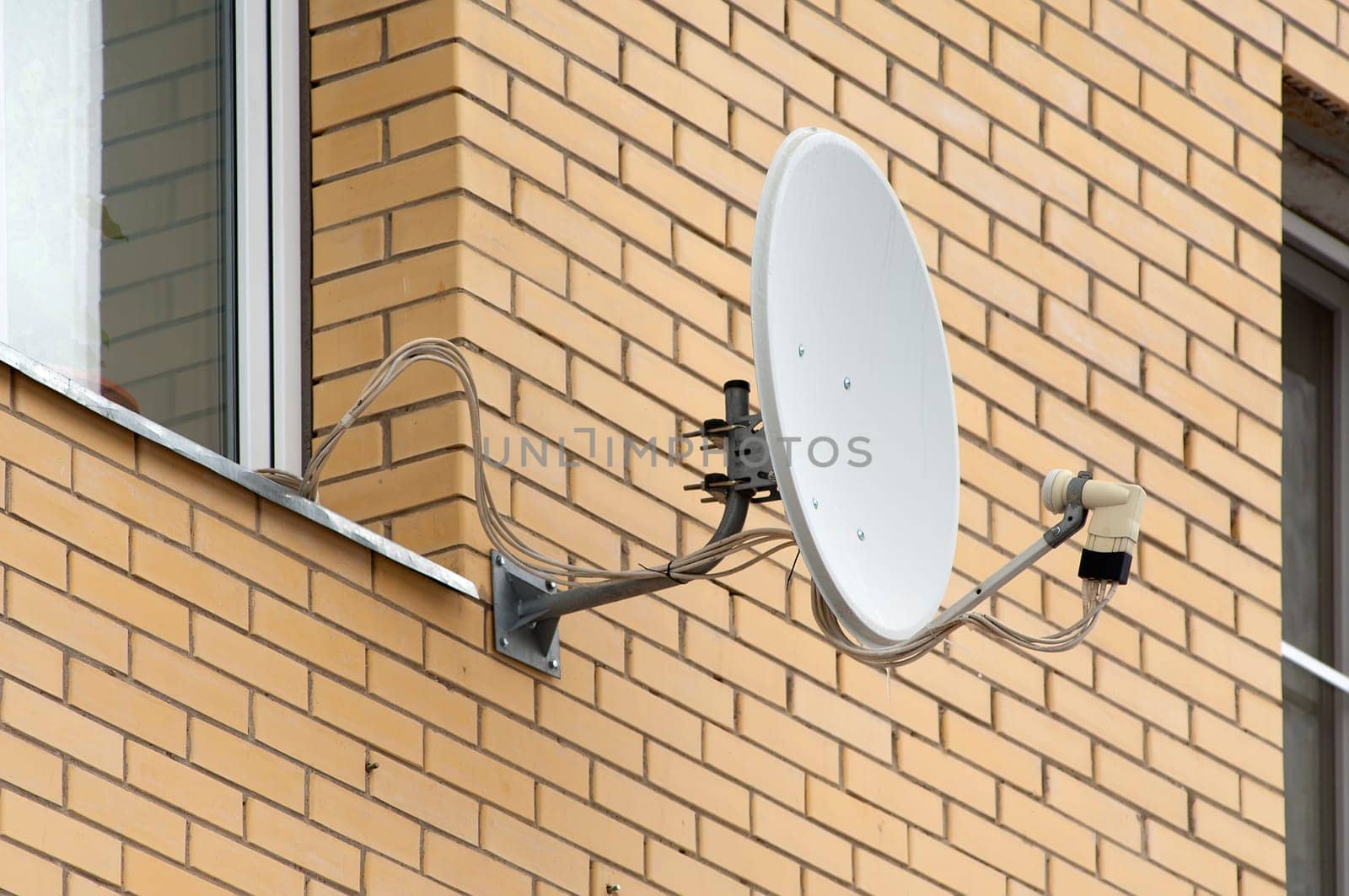 Antenna on wall near the window. Brick wall