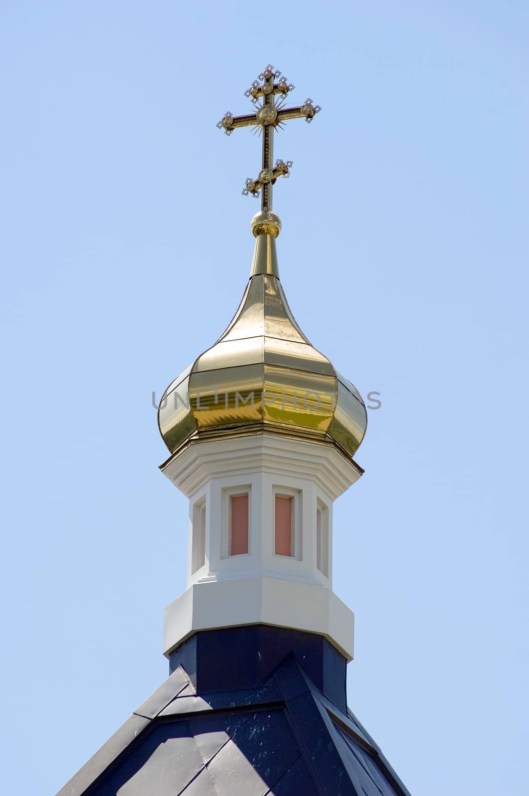 Golden dome of the Orthodox church in Optina hermitage on the blue sky background
