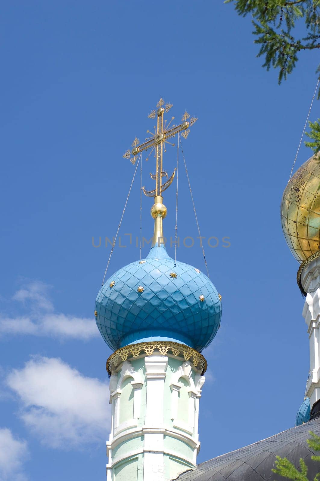 Golden dome of the Orthodox church in Optina hermitage on the blue sky background