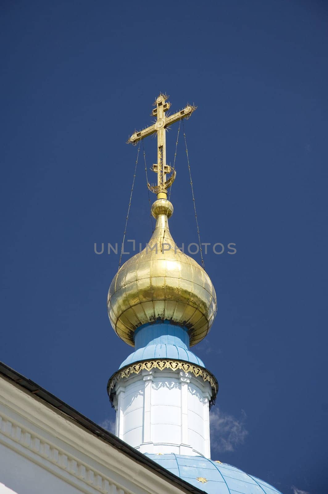 Golden dome of the Orthodox church in Optina hermitage on the blue sky background