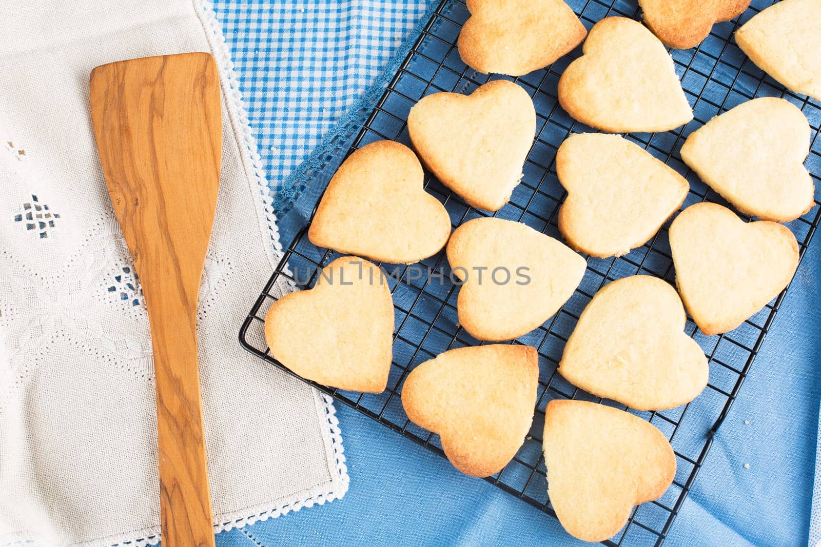 Fresh baked heart shaped cookies on cooling rack.