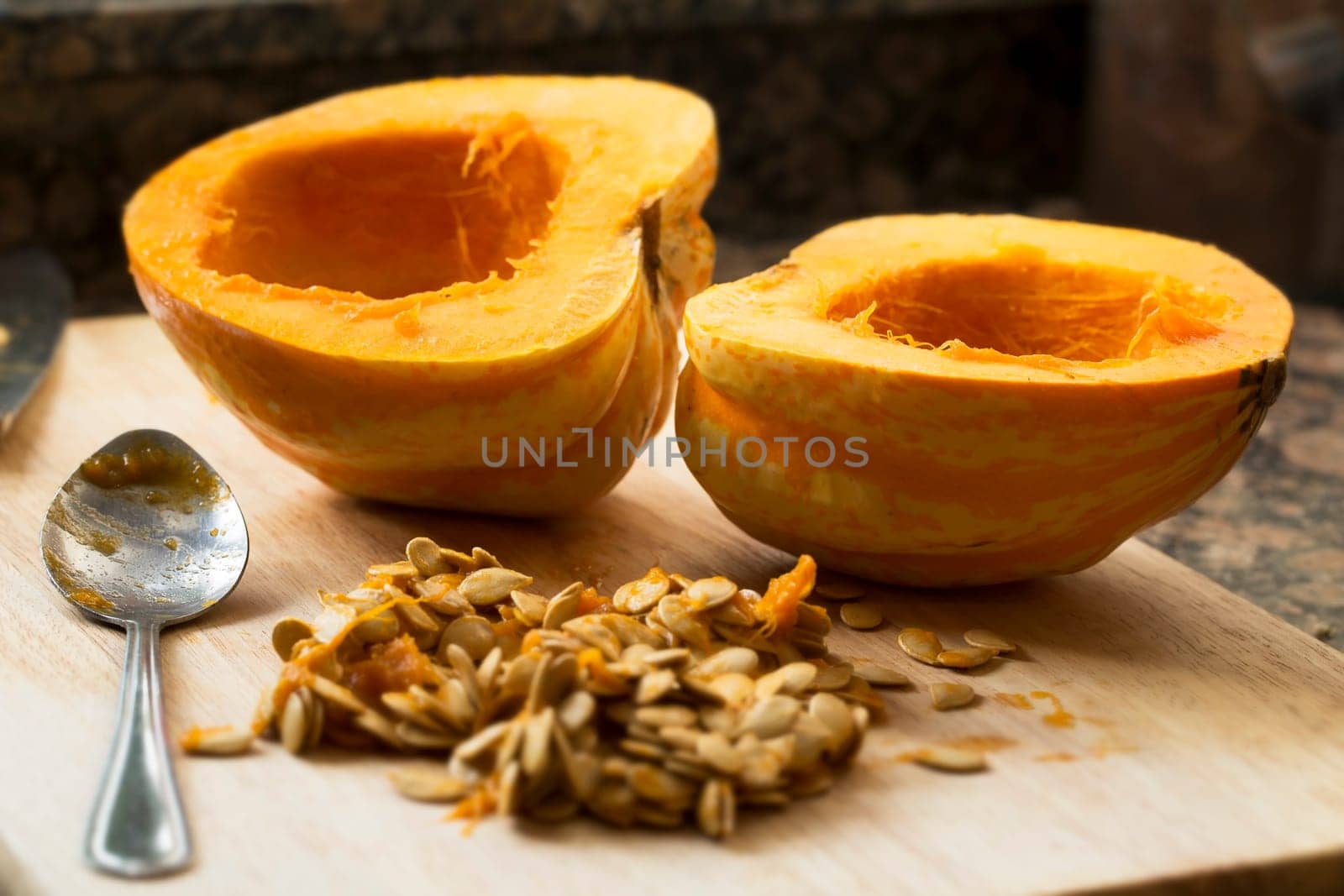 Winter squash cut in half with spoon and seeds scooped out.