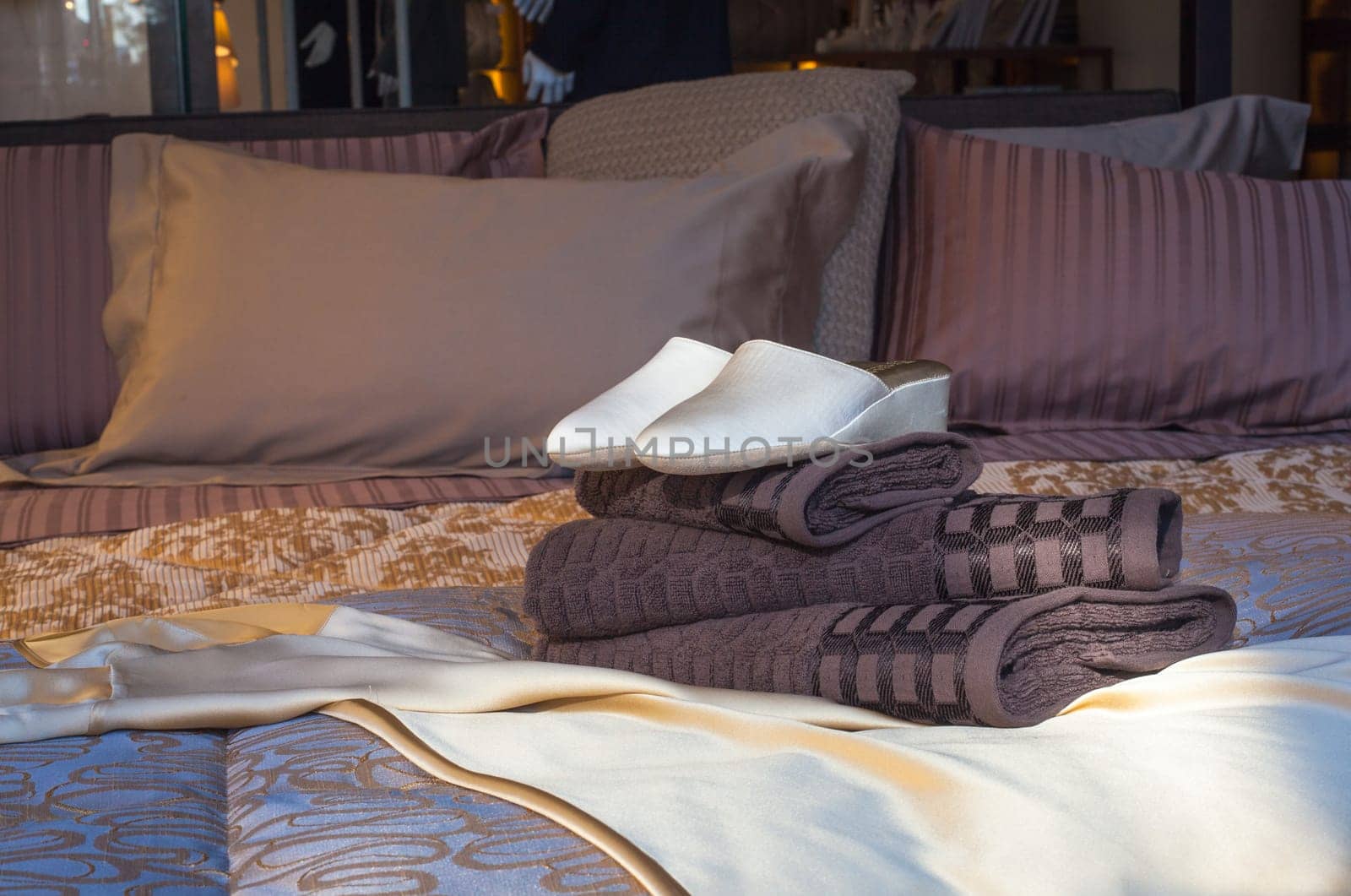 White female slippers on the towels in the bed