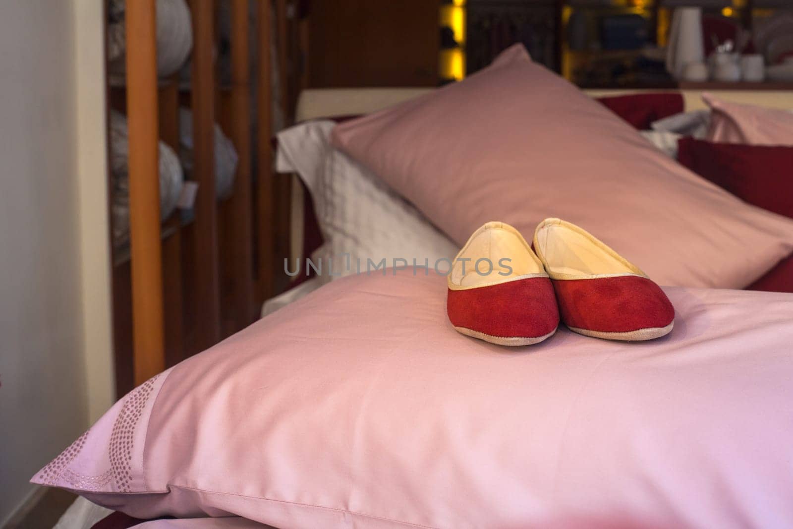 Red female slippers on the pink pillow