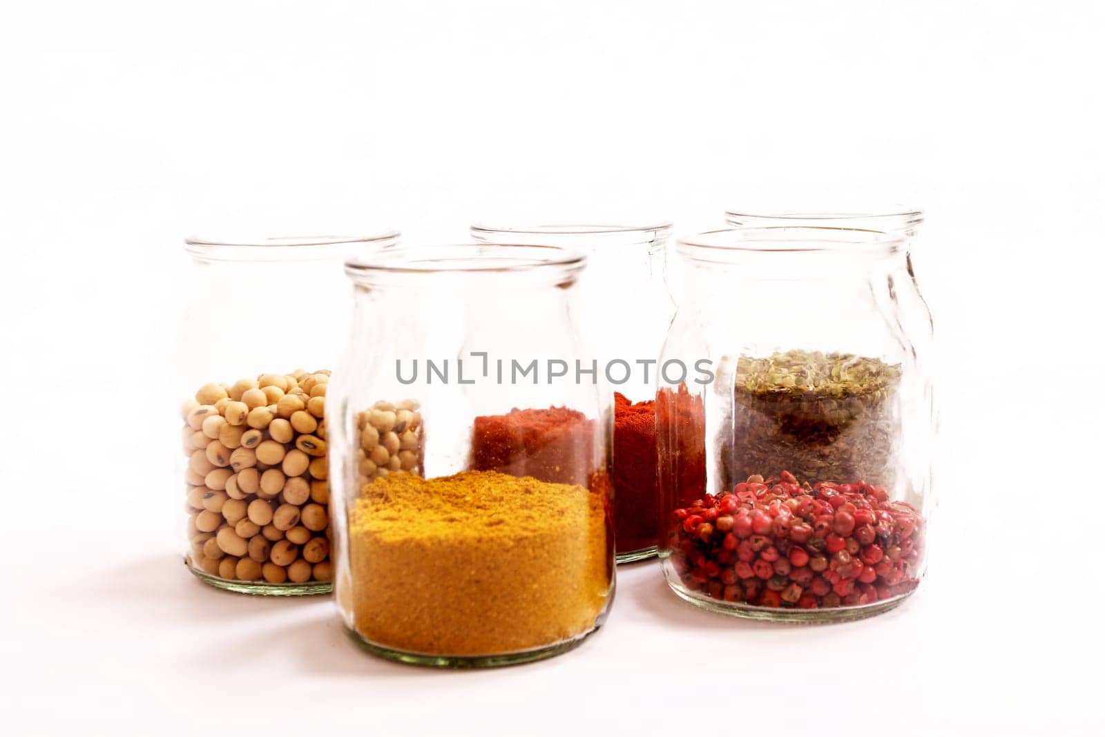 Variety of spices and legumes in a glass pot..