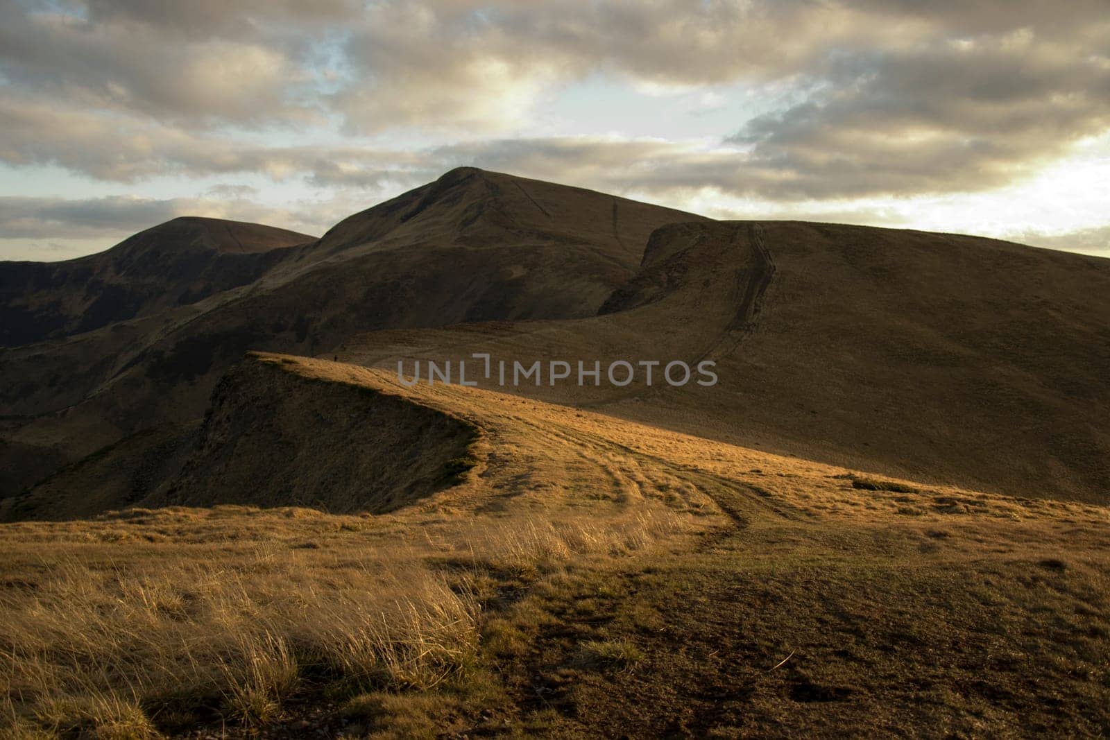 Mountain peaks in the autumn evening sky with clouds.