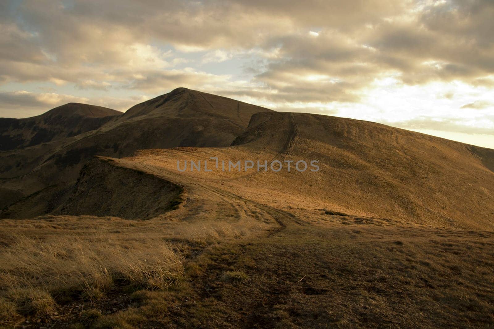Mountain peaks in the autumn evening sky with clouds.