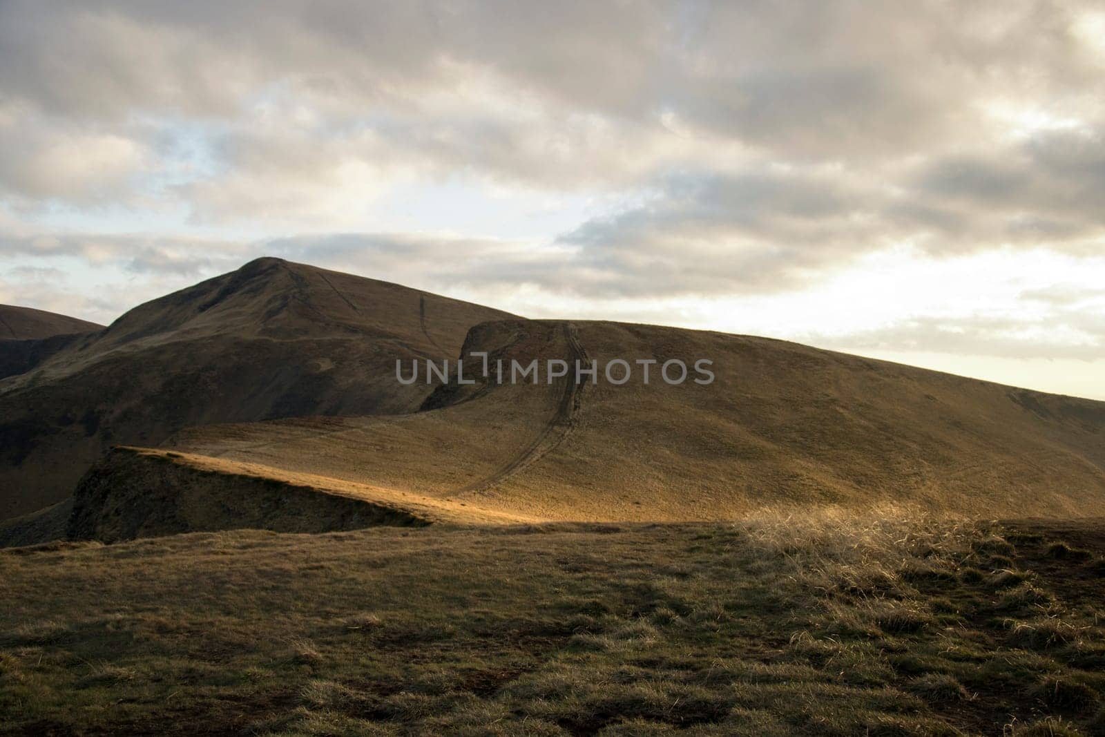 Mountain peaks in the autumn evening sky with clouds.