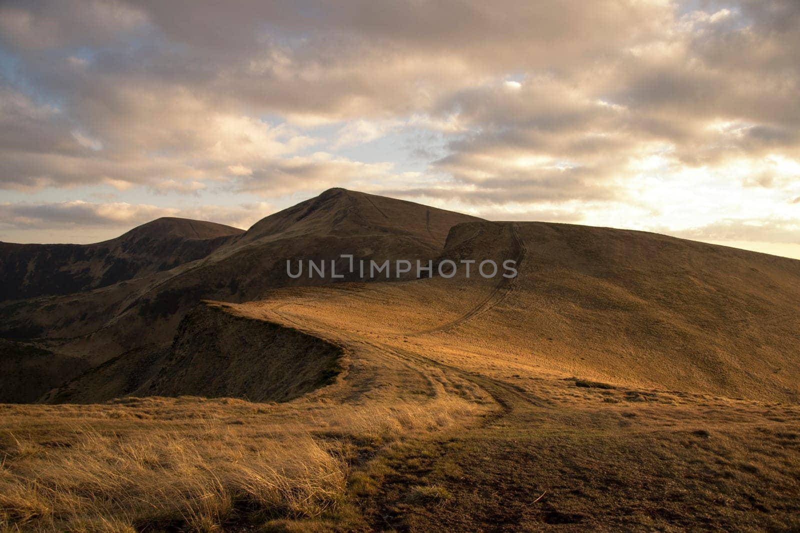 Mountain peaks in the autumn evening sky with clouds.