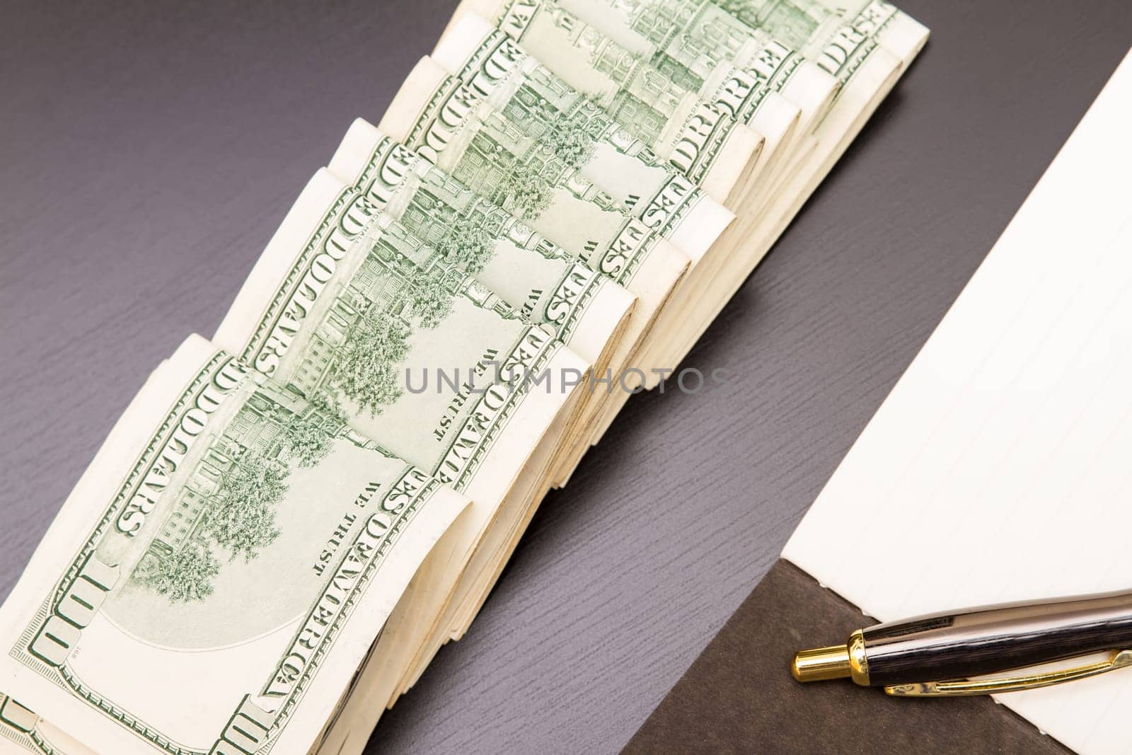 Lots of dollars with an open copybook.