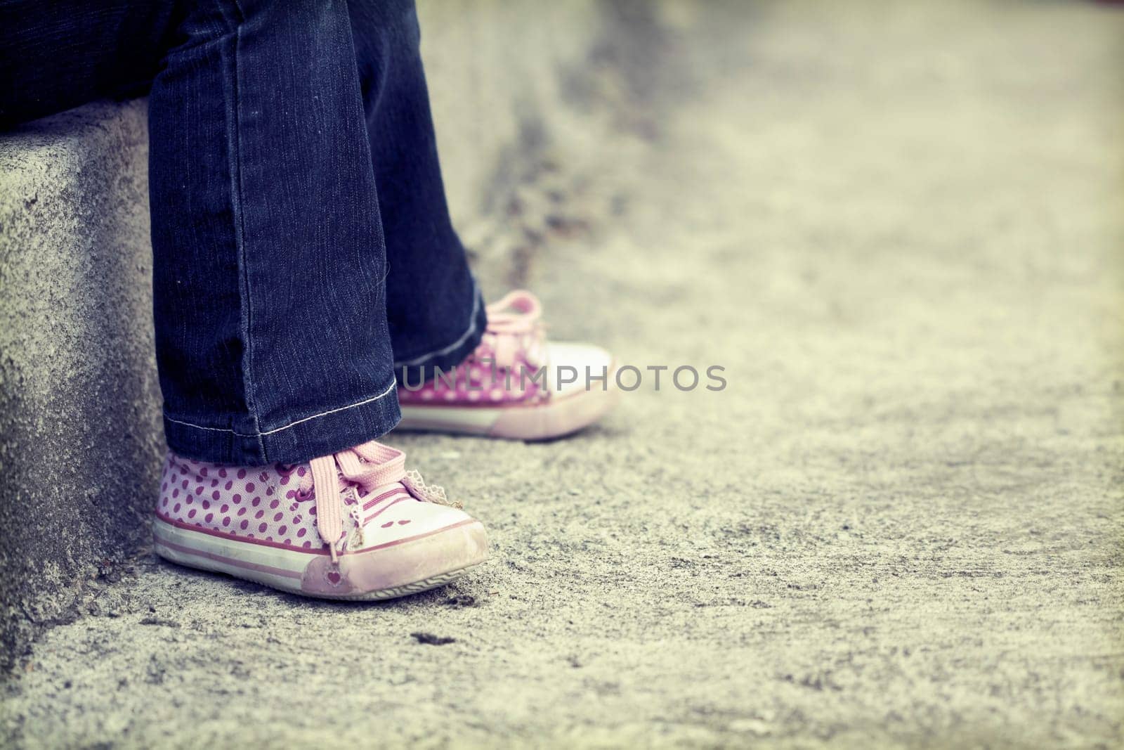 Vintage photo of lonley girl sitting in the schoolyard