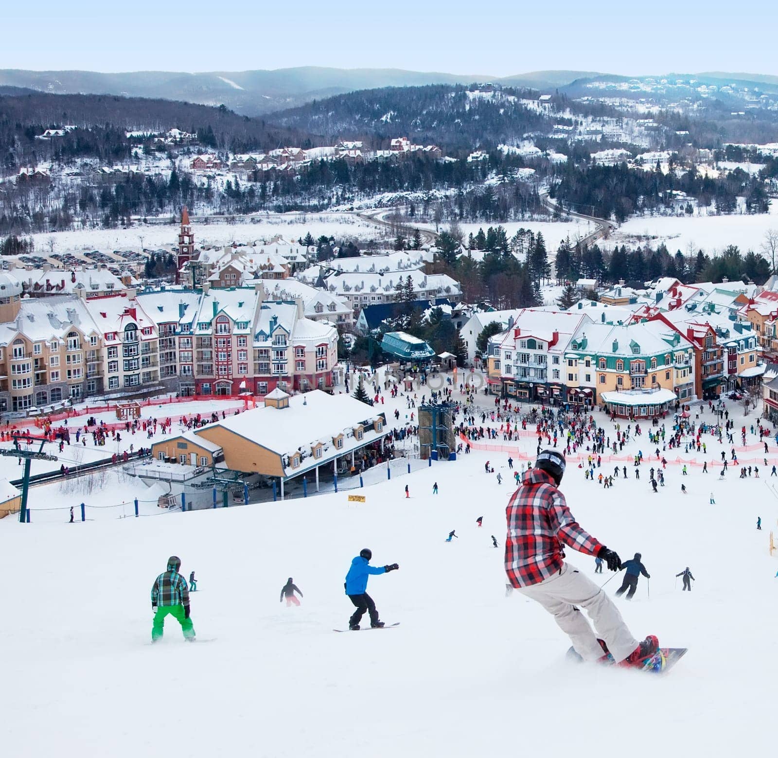 Mont-Tremblant, Canada - February 9, 2014: Skiers and snowboarders are sliding down the main slope at Mont-Tremblant. Mont-Tremblant Ski Resort is acknowledged by most industry experts as being the best ski resort in Eastern North America.