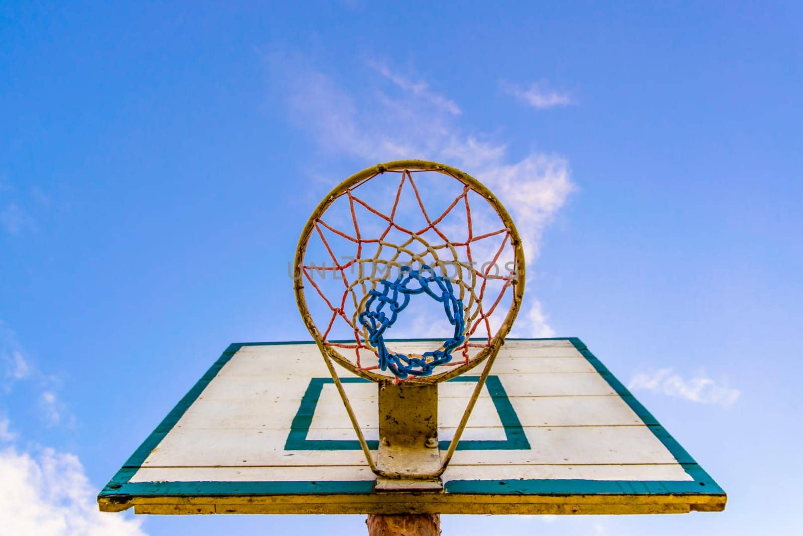 old style basketball basket with blue board in the background.