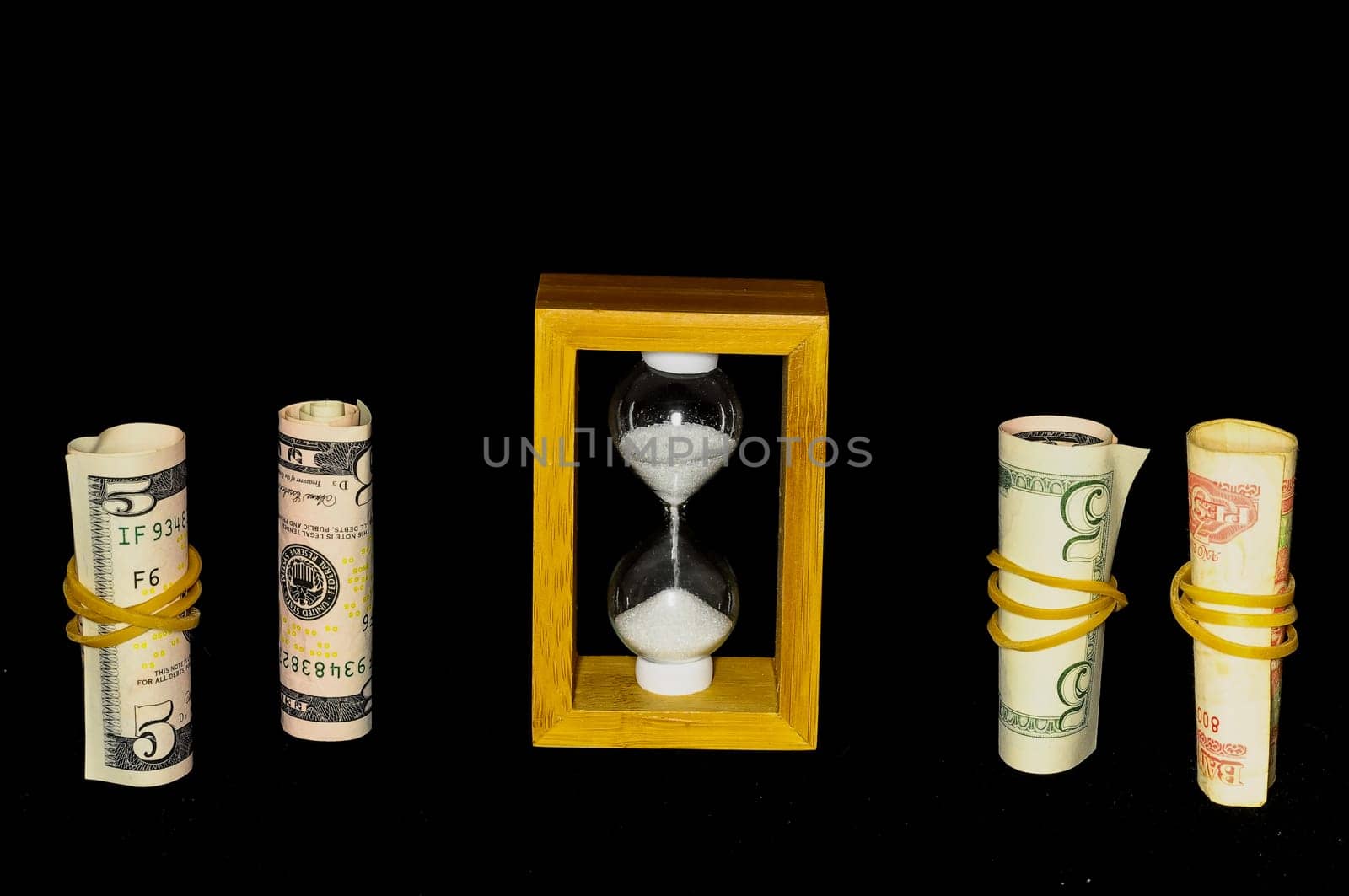 Buisness Time Concept Hourglass and Money on a Black Background