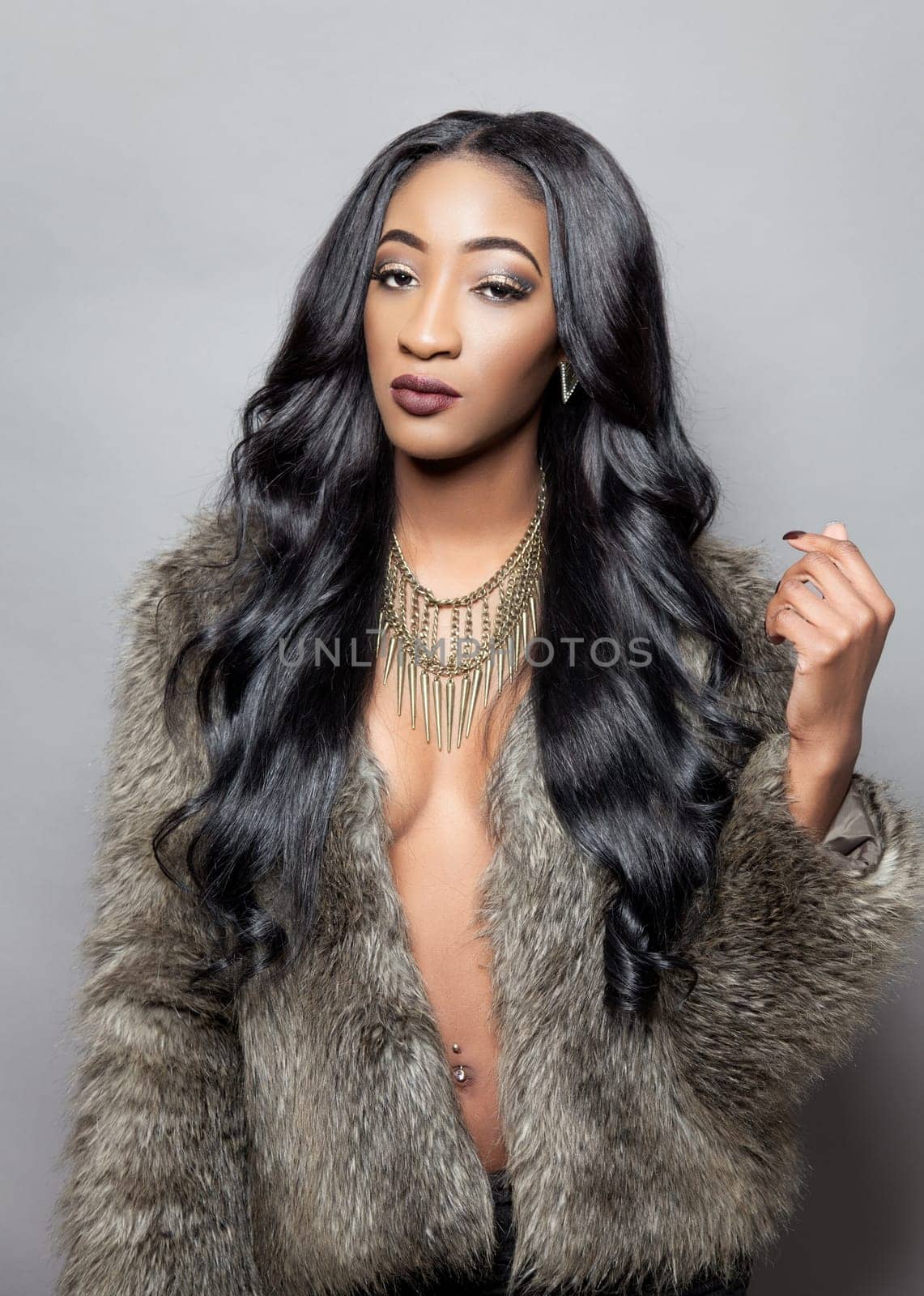 Beautiful black woman with long curly hair wearing a fur coat