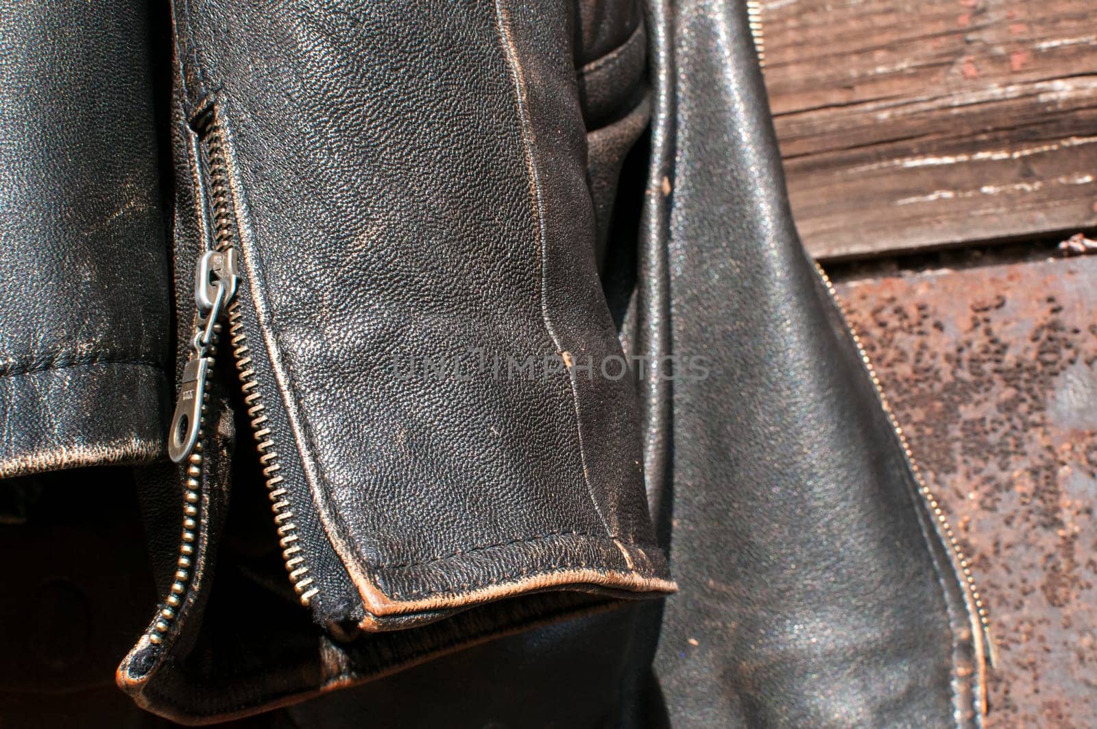 Vintage leather male jacket sleeve on old  railway wagon background