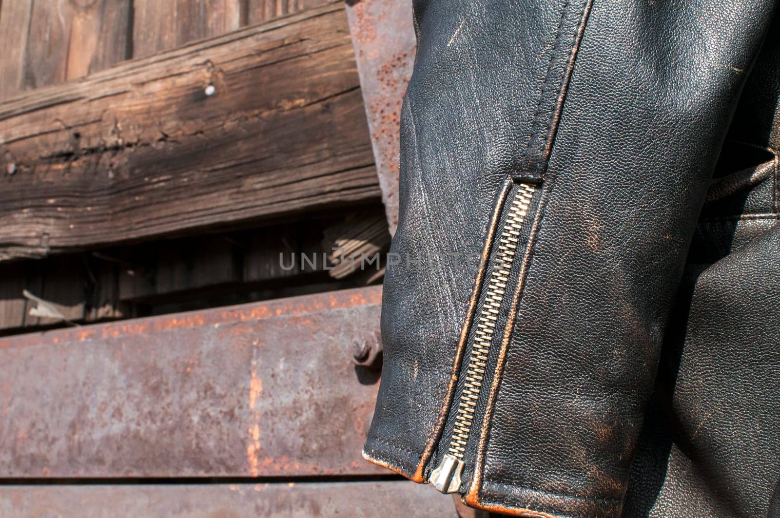 Vintage leather male jacket sleeve on old  railway wagon background