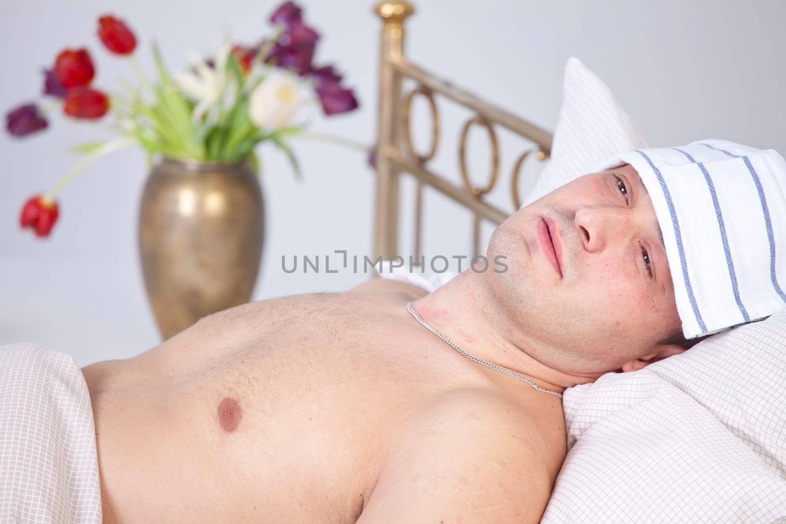 Sick man lying on bed with pain in face