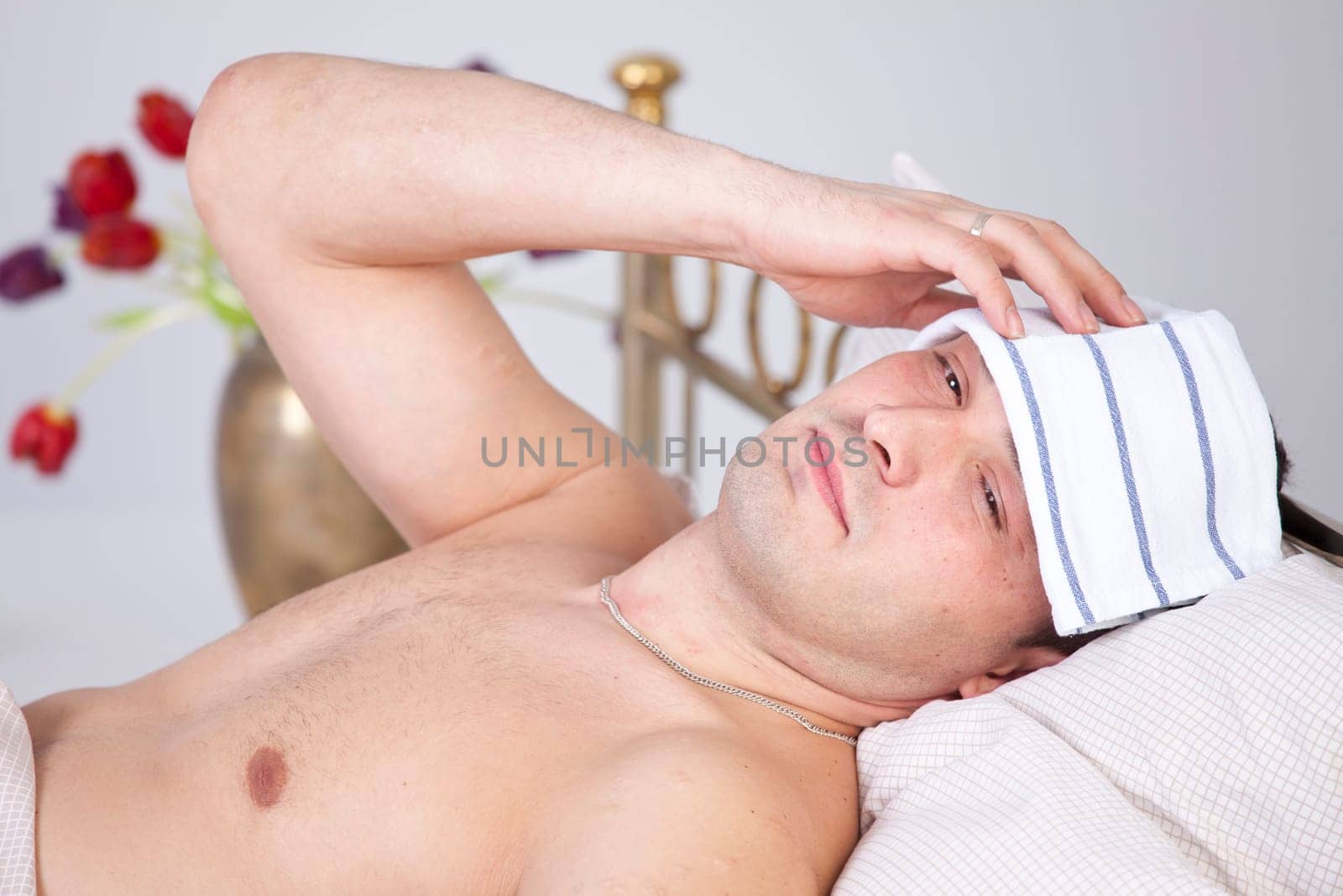 Sick man with headache lying on bed