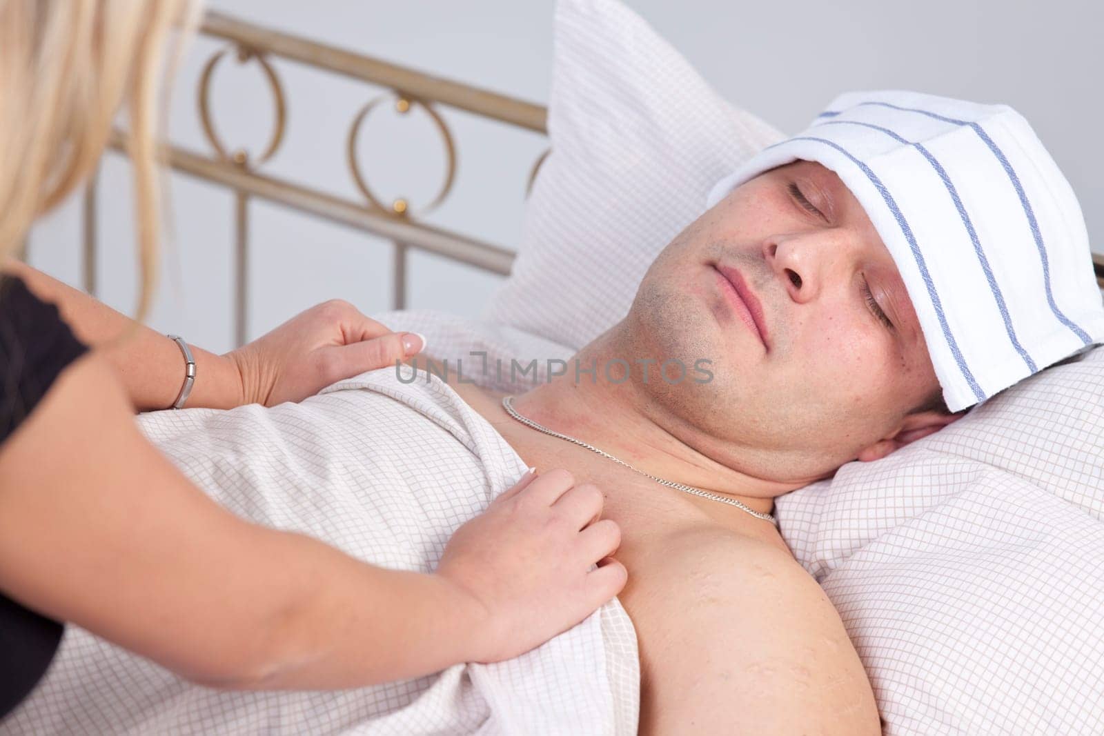 woman caring for sick man on the bed
