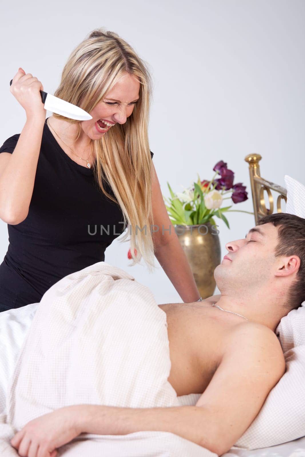 Angry wife with knife wants to kill her sleeping husband on bed - Jealousy scene
