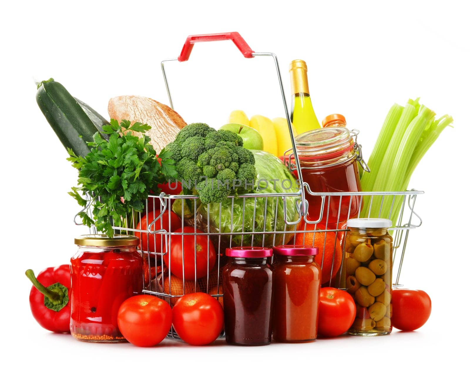 Wire shopping basket with groceries isolated on white