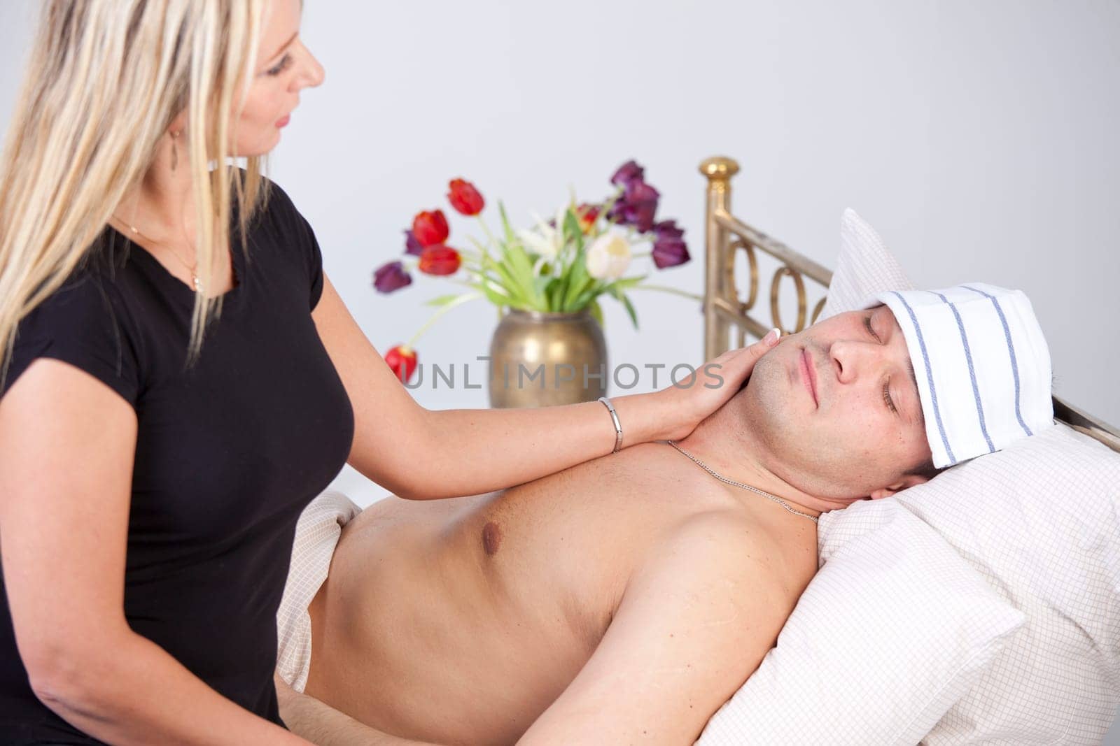 Sick man on bed - woman nursing him