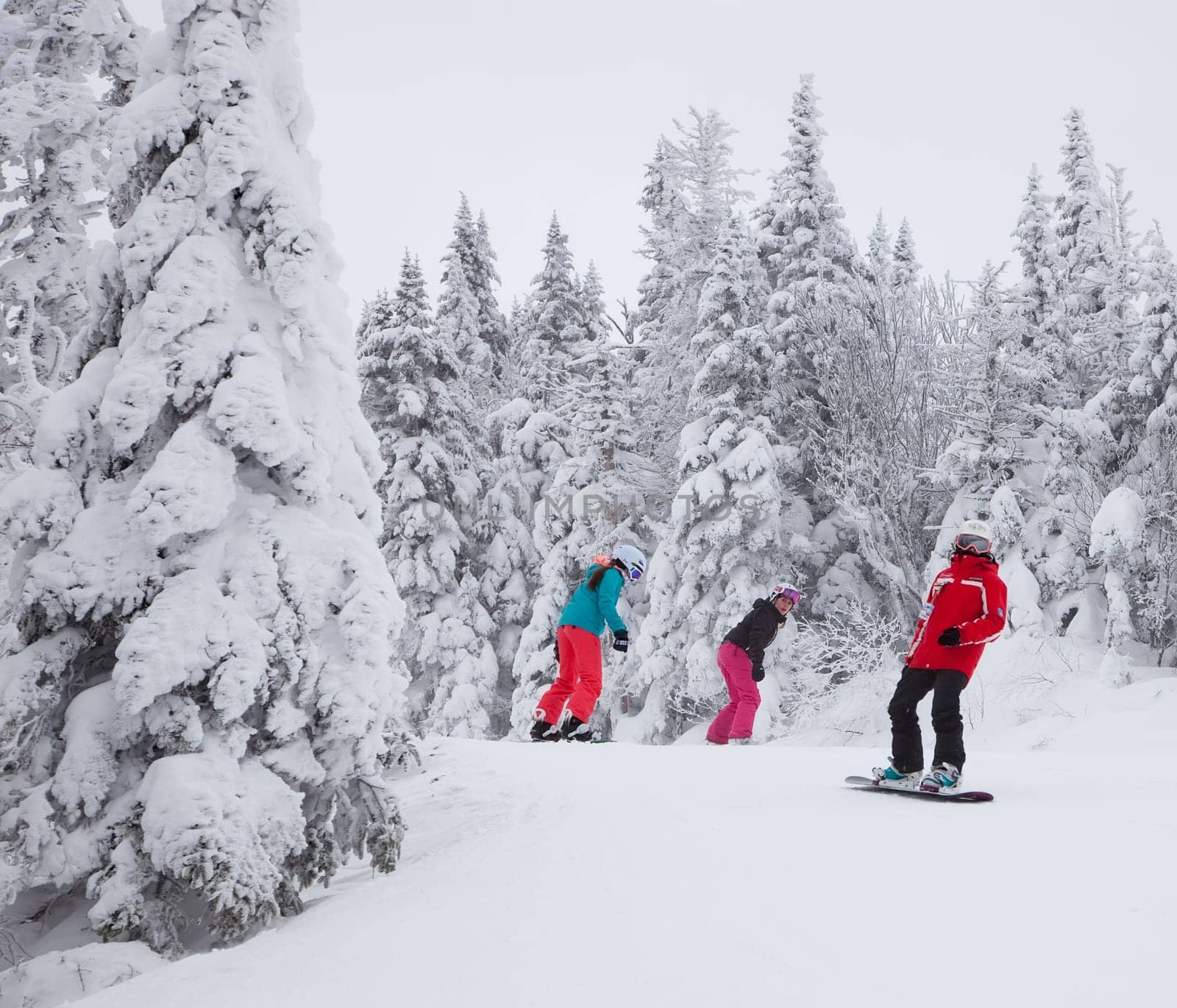 Mont-Tremblant, Canada - February 9, 2014: Snowboarders are sliding down an easy slope at Mont-Tremblant. Mont-Tremblant Ski Resort is acknowledged, by most industry experts, as being the best ski resort in Eastern North America.