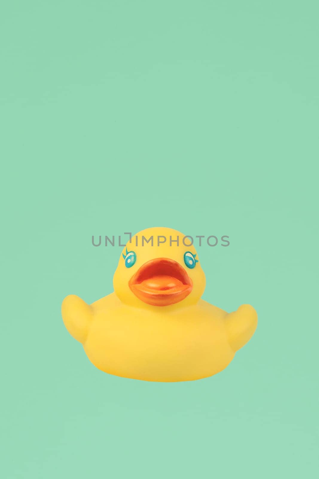Yellow rubber duck on an emerald background. by Sviatlana