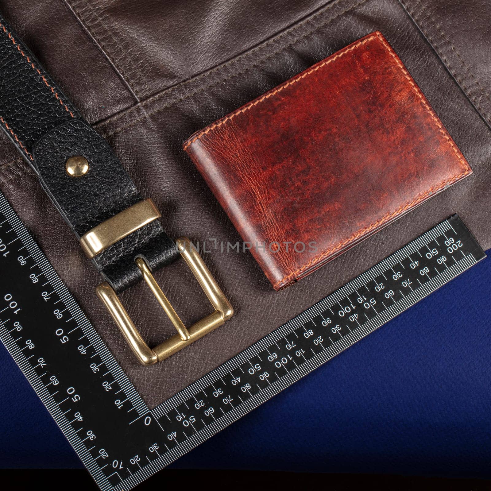 Leather goods purse and belt against the background of a ruler for cutting and sewing. by Sviatlana