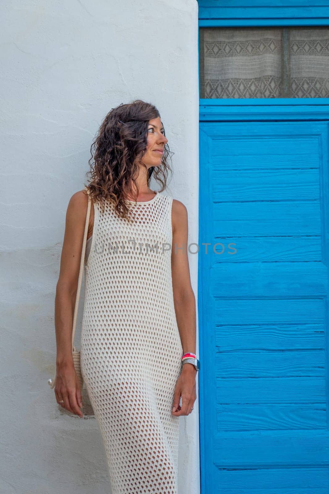 Woman in white dress next to an old blue door by LopezPastor