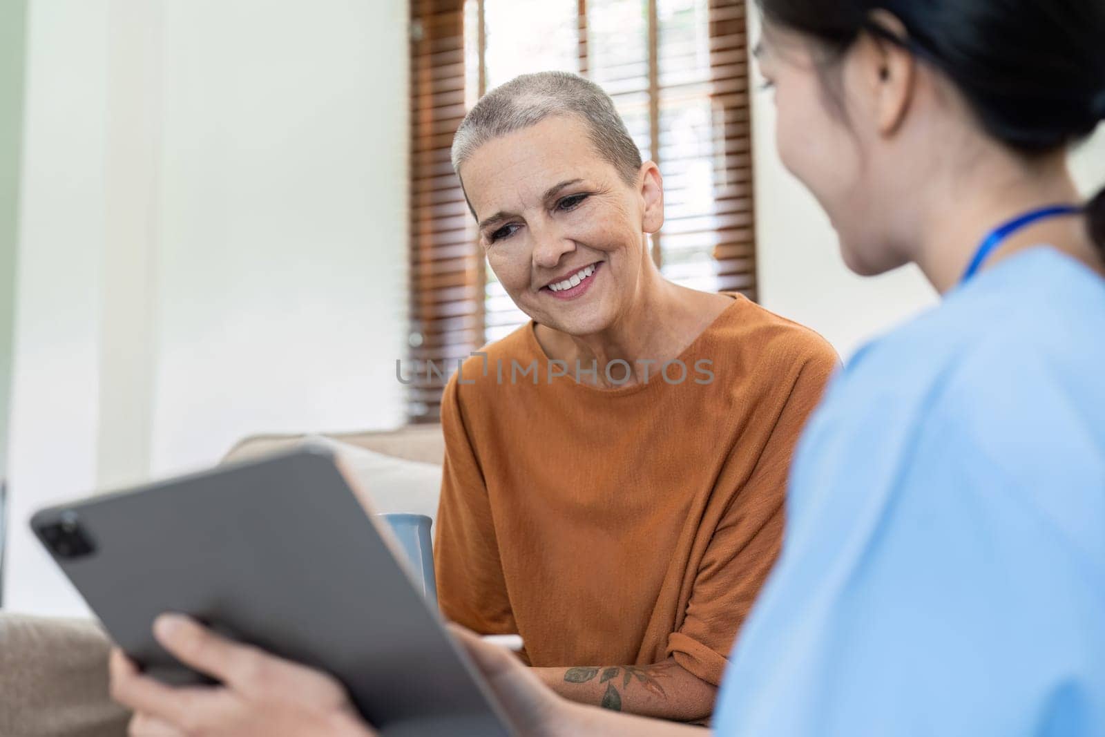 Asian nurse showing health checkup report to older and giving advice. Home nursing and healthcare caregiver concept.